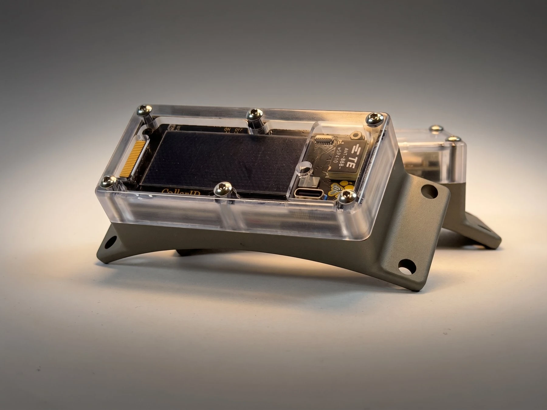 CollarID hardware with a solar panel, sensors, and antennas beneath its clear enclosure